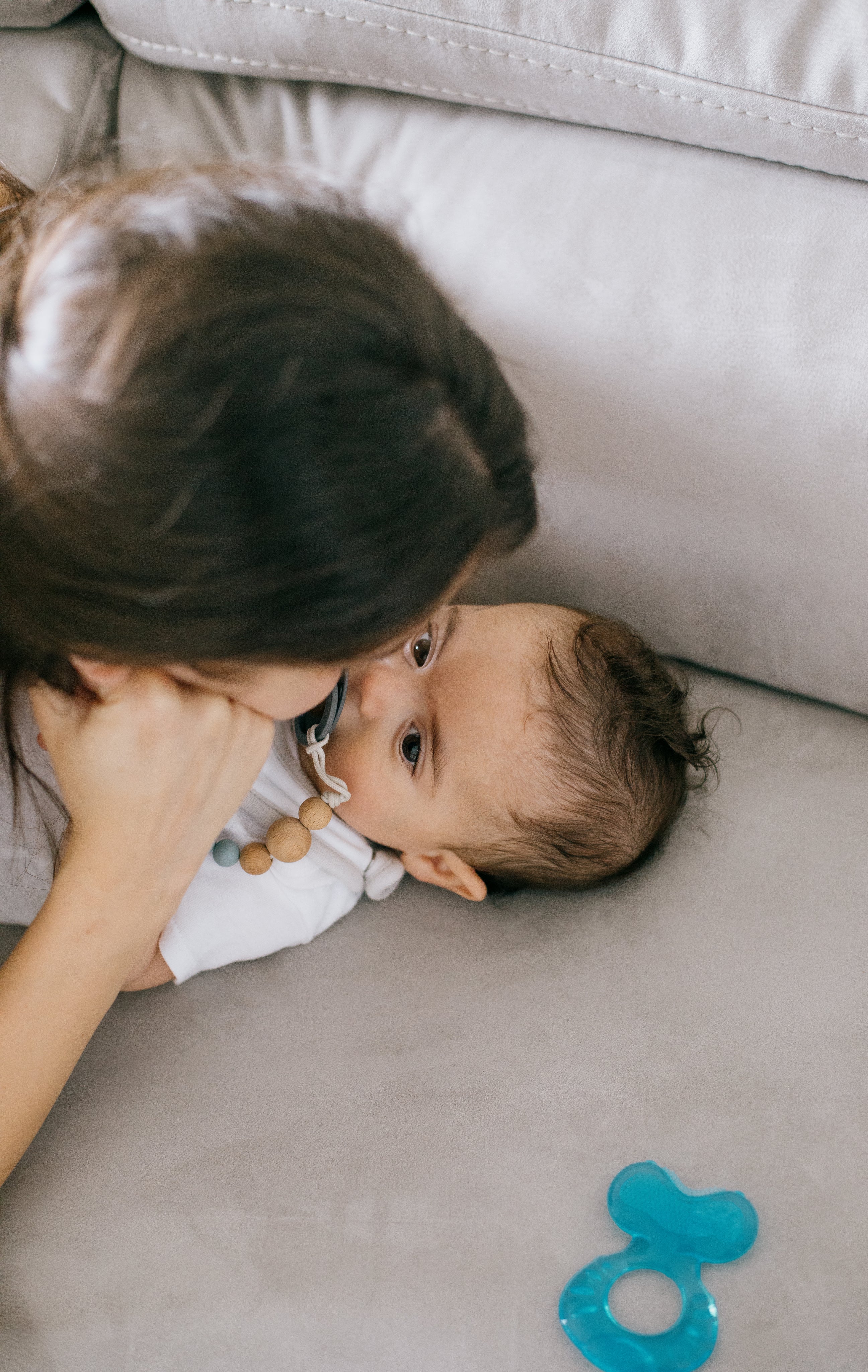 files/baby-and-a-person-lay-close-on-a-white-couch.jpg
